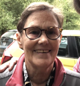 A smiling woman with short brown hair and glasses